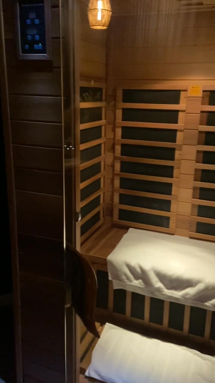 The infrared sauna at Rise, softly lit with a warm pendant light
